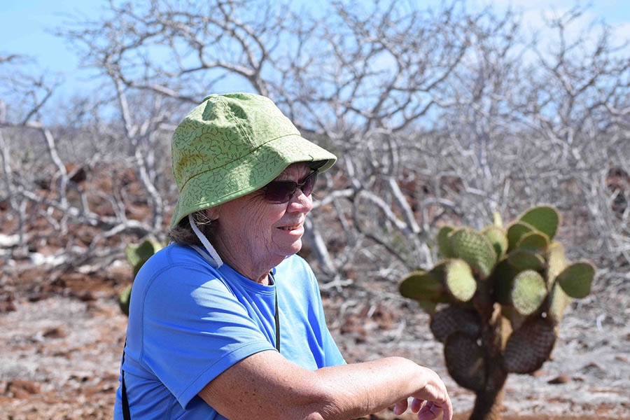 An older lady wears a hat in the desert.